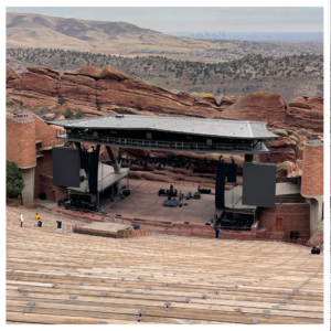Empty Red Rocks amphitheater with seats, stage, and view of Denver in the distance