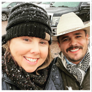 A woman in a knit hat, scarf and jacket with a man in a cowboy hat, scarf and jacket, tailgating at Red Rocks