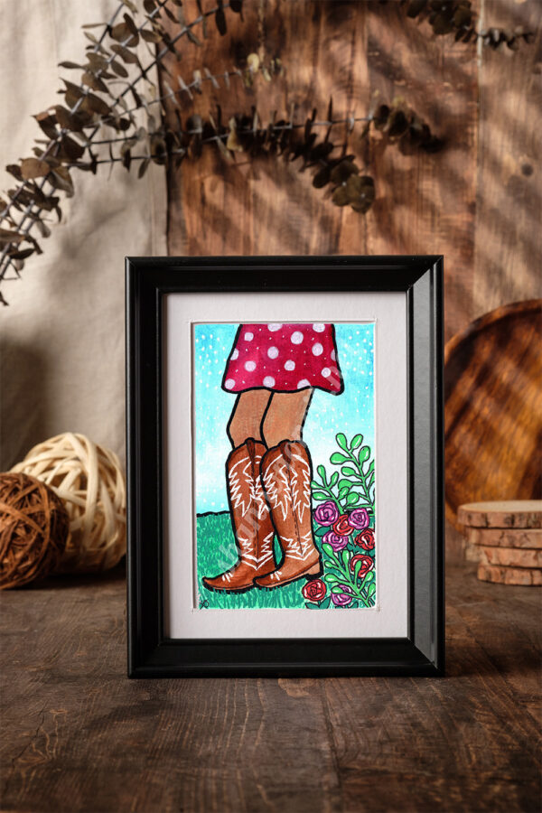 Sun-kissed legs in brown cowboy boots kick up just a little, the red polka-dot skirt swaying in a breeze that knows a secret. The wildflowers flirt, the grass leans closer—because even nature knows she’s got a way of turning heads.